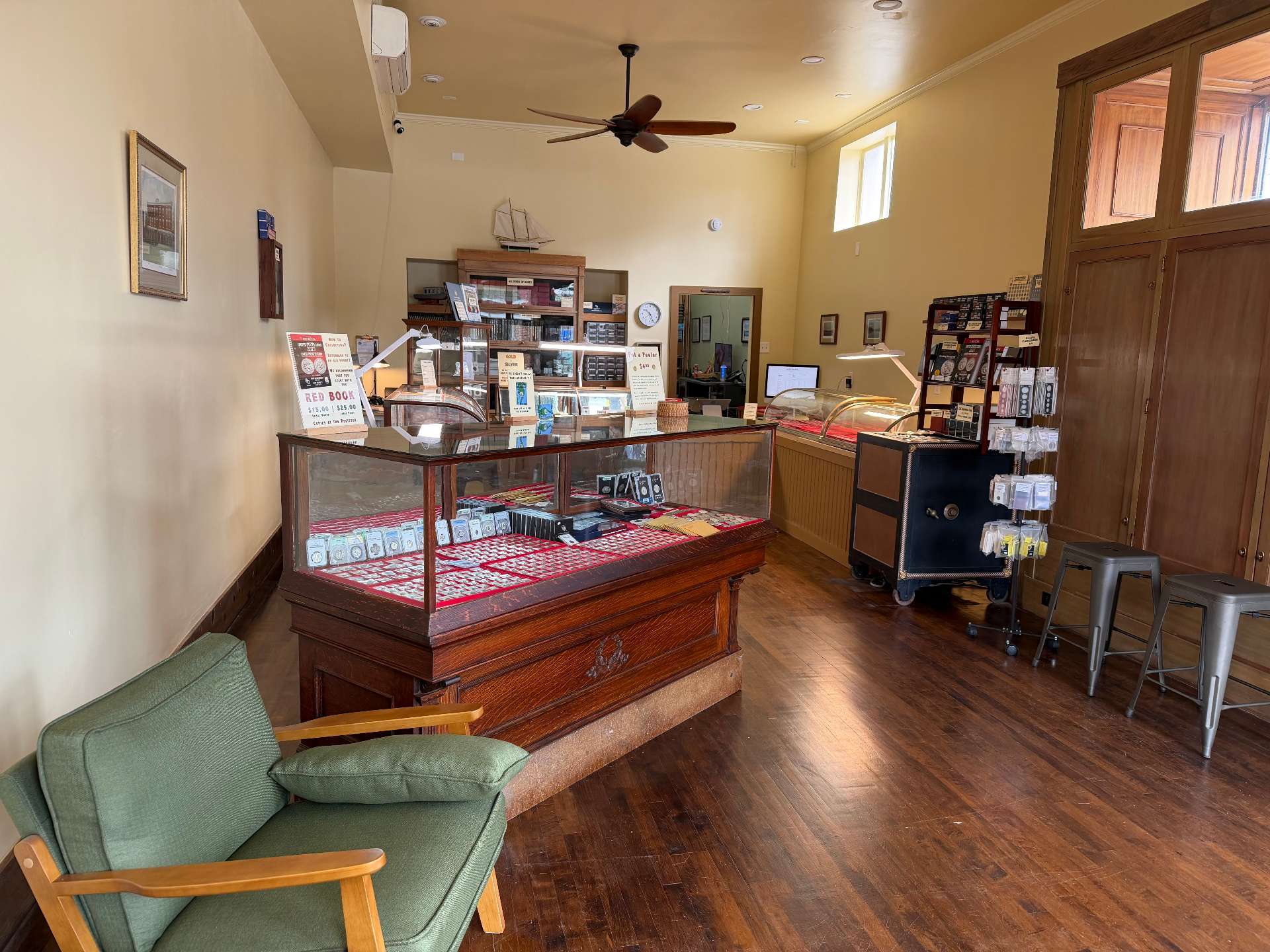 Wide view of the LSCEX showroom with green armchair, display cases, and supplies rack